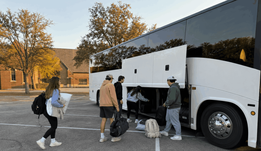 youth church group loading bags onto a charter bus in fort worth before a retreat