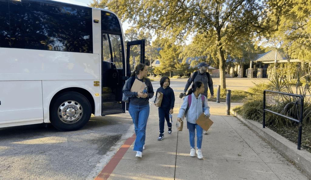 school bus dropping off students and chaperones near the fort worth zoo entrance for a field trip