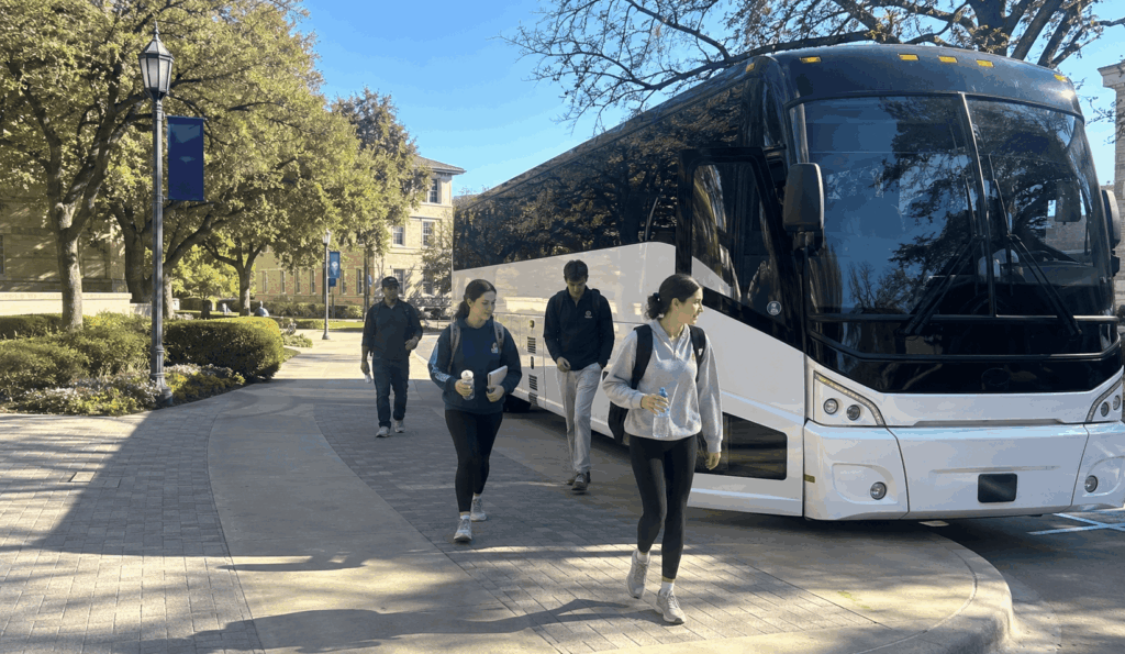 charter bus dropping off students near the tcu visitor center area for a campus tour in fort worth