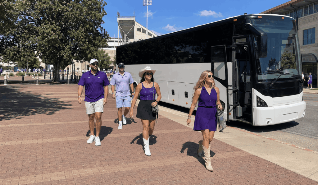 charter bus dropping off tcu football fans near amon g. carter stadium in fort worth