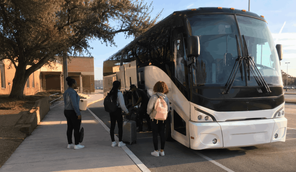charter bus picking up students in fort worth for a multi-day texas college tour